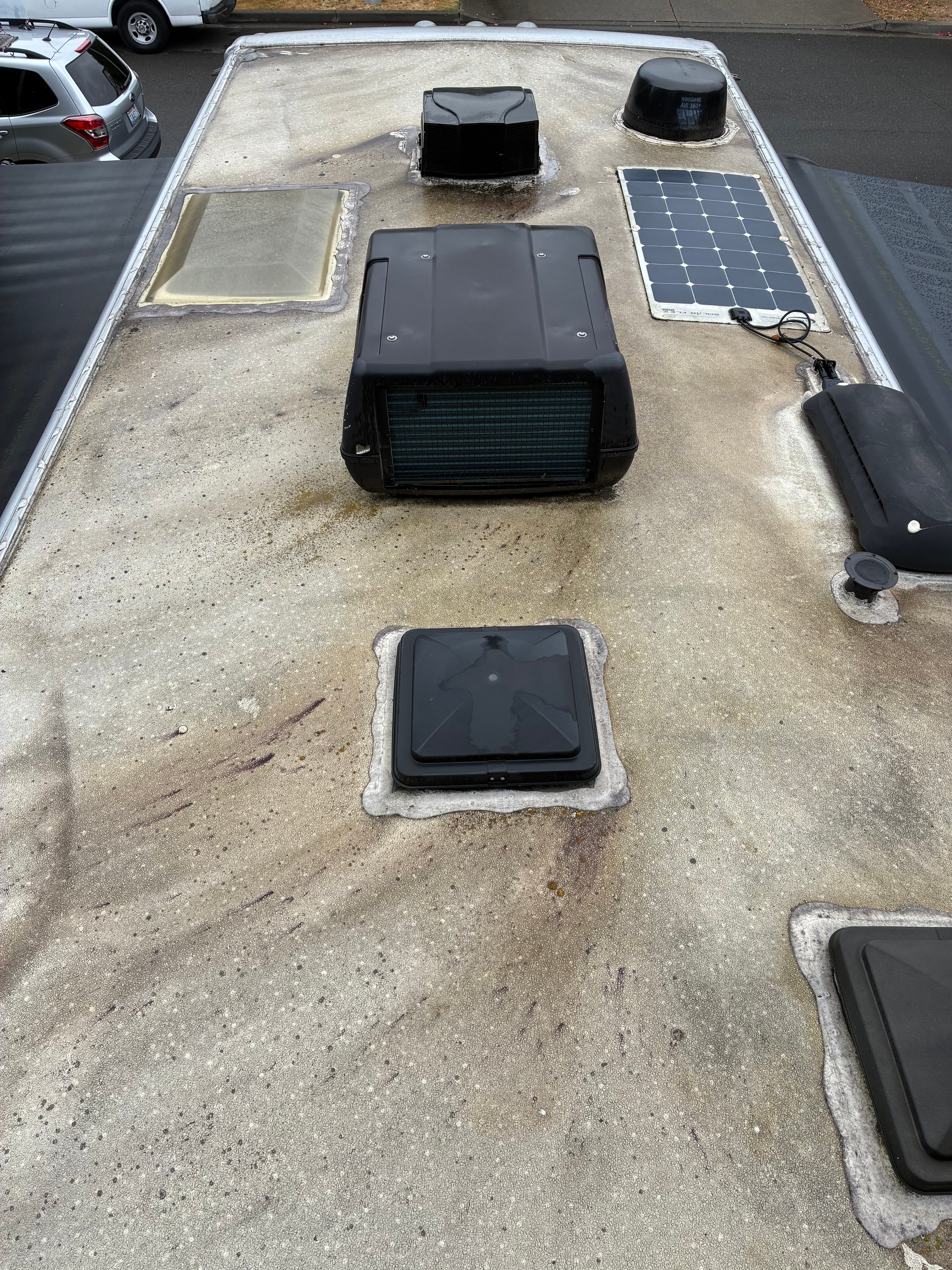 Class C motorhome roof with heavy buildup before professional exterior wash and wax in Marysville, WA