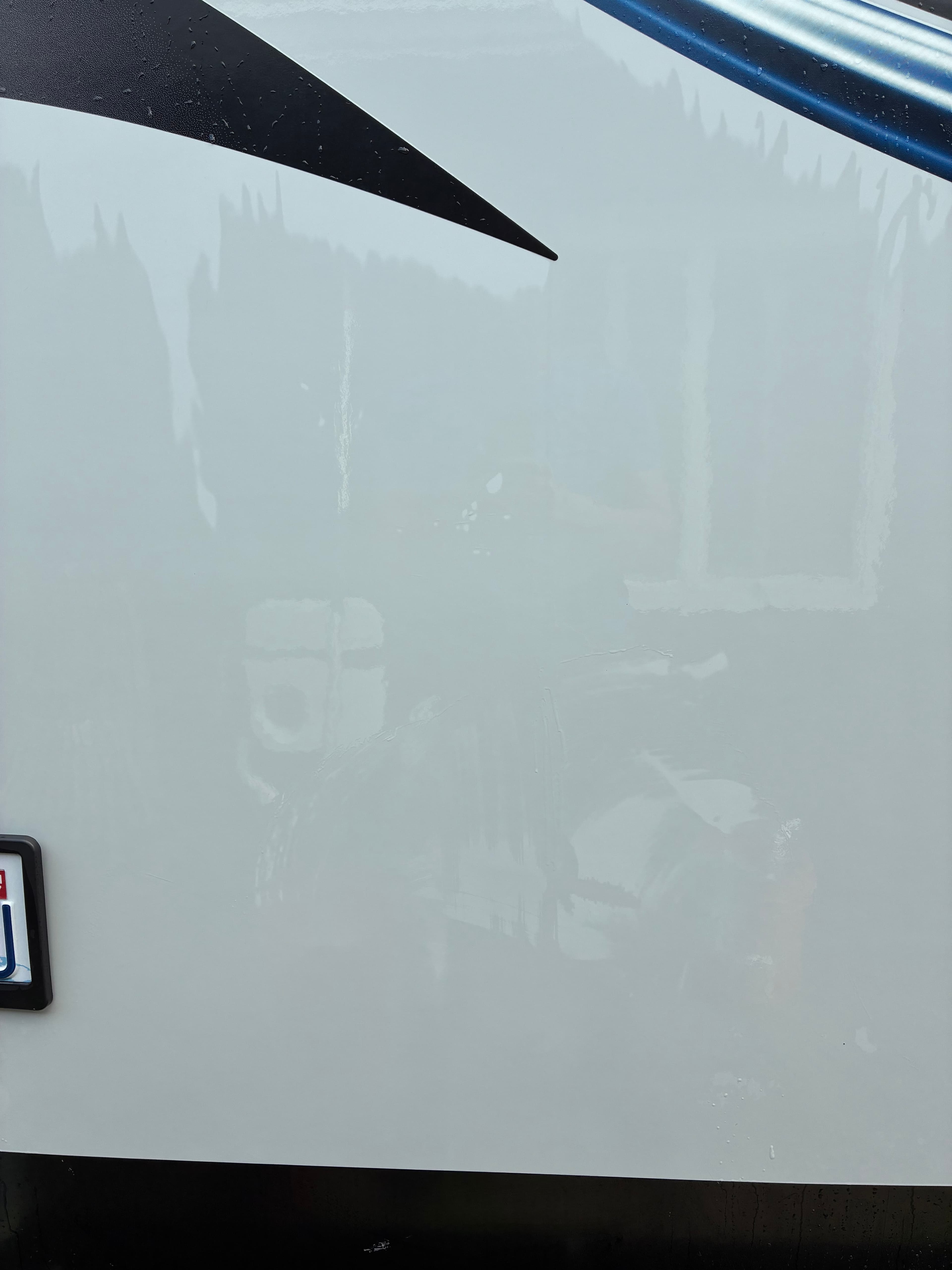 Travel trailer side panel with deep glossy wax finish and clear reflections after professional detailing in Snohomish, WA