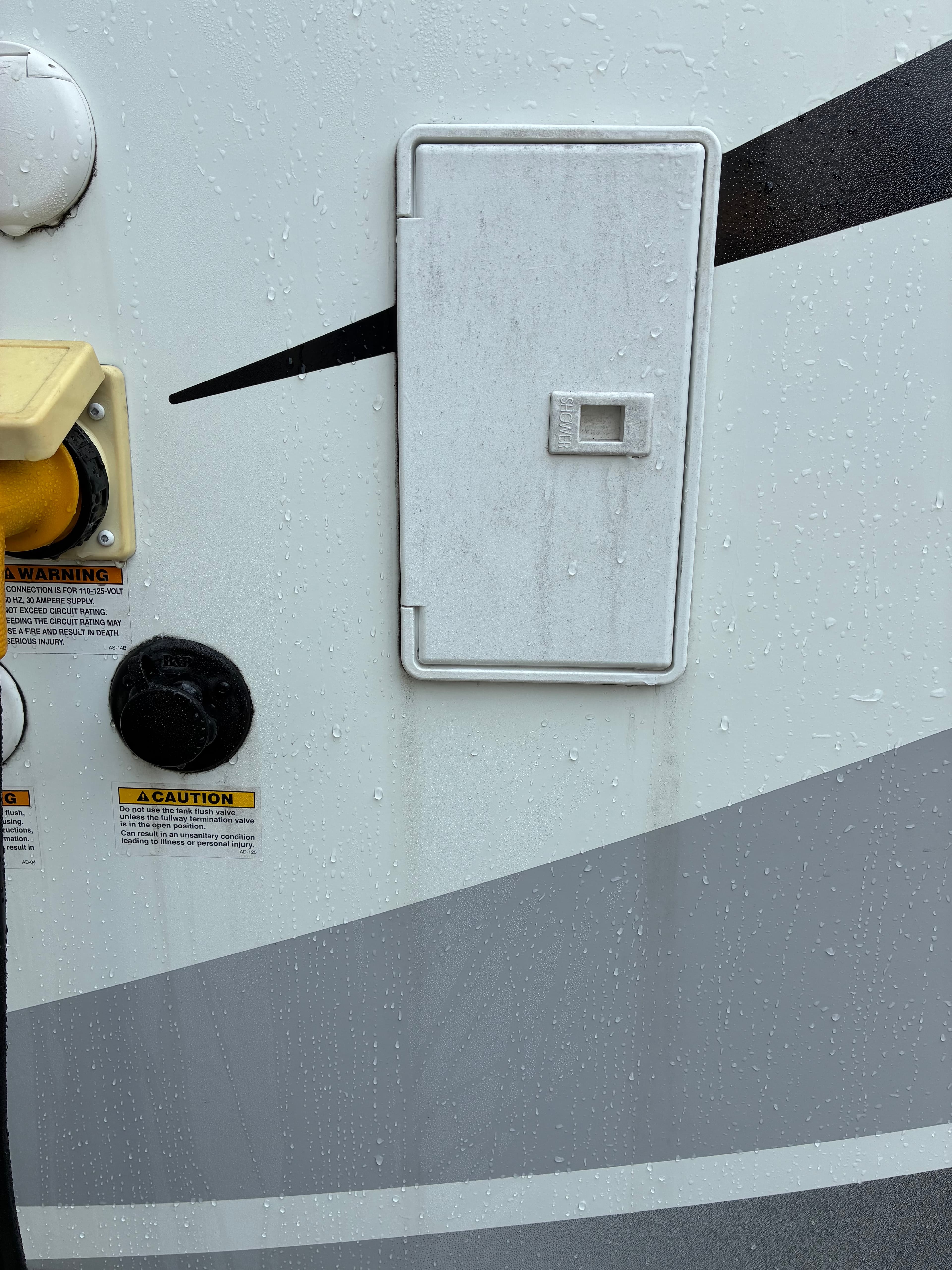 Motorhome utility compartment panel with water spots and grime before mobile wash and wax in Snohomish, WA